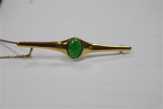 A Chinese yellow metal and jadeite cabochon bar brooch, 62mm.